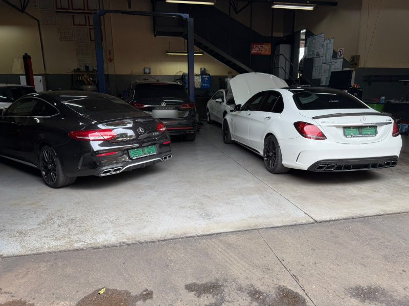 Two Mercedes-AMG C63s and a Volkswagen Touareg in the Q&A Auto Repairs workshop