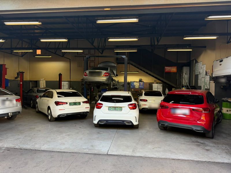 Five cars lined up in the Q&A Auto Repairs workshop bays, one raised on a lift